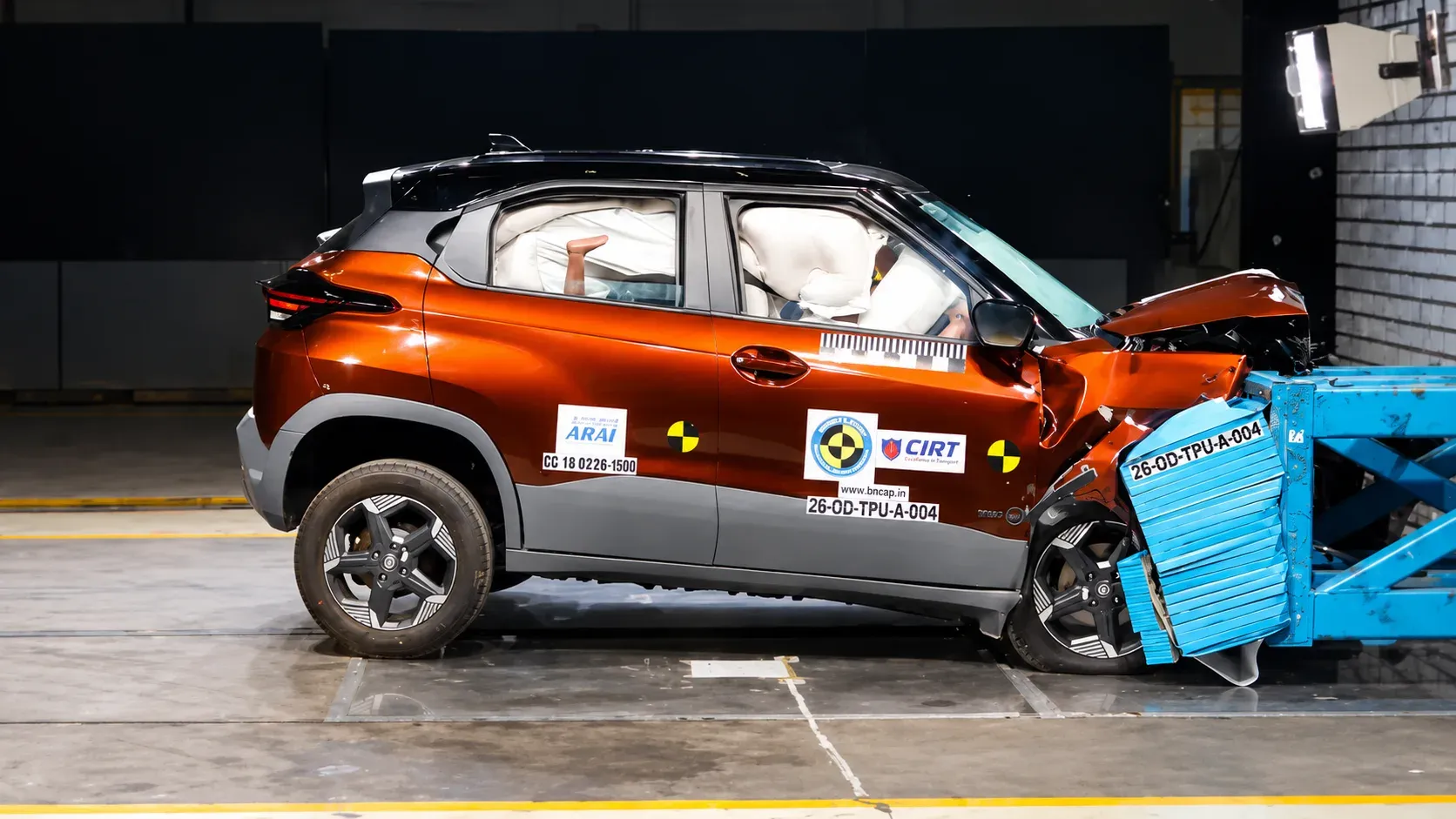 Side view of a Tata Punch EV after a frontal crash test showing deployed airbags and front-end damage